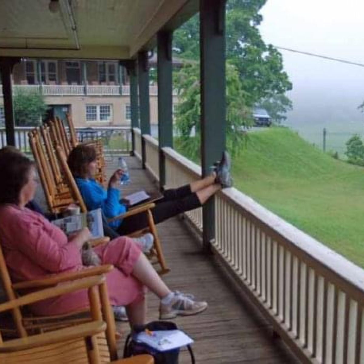 Retreat participants relaxing on the porch in Valle Crucis, sharing conversations in the mountain air.